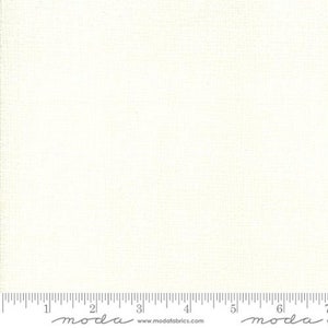 May include: A white fabric with a subtle texture. The fabric is shown with a ruler for scale.
