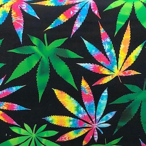 May include: A black background is covered with cannabis leaves in shades of green and tie-dye. The tie-dye leaves feature a blend of pink, yellow, blue, and orange. The green leaves have a gradient effect, with darker edges and lighter centers.
