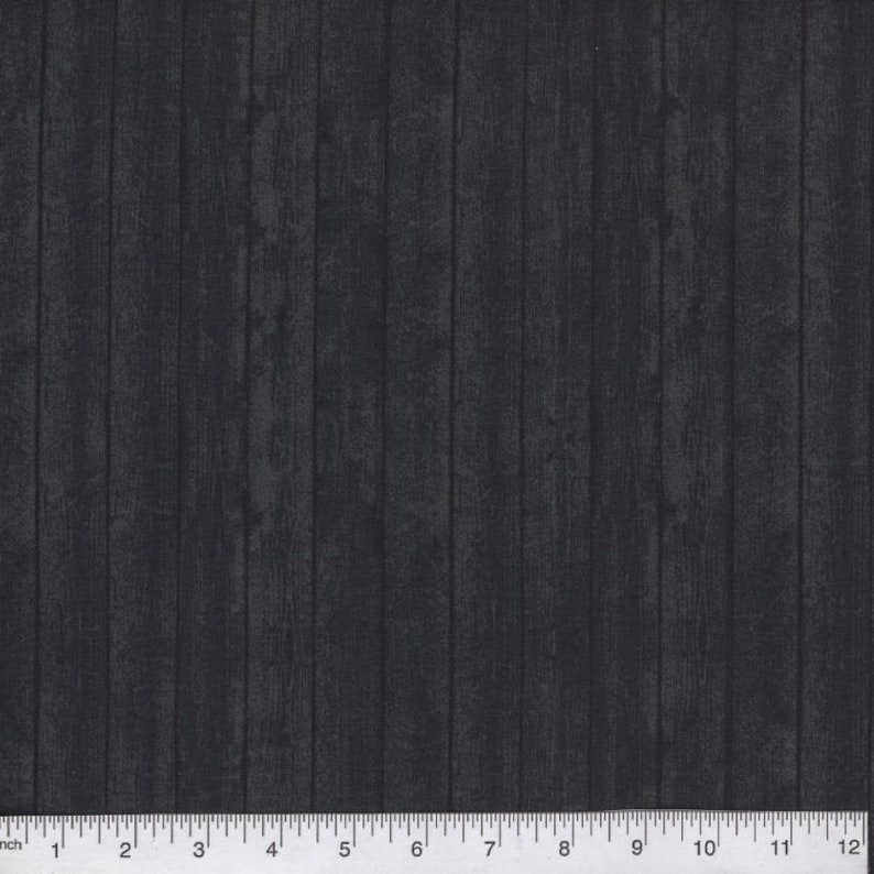 May include: Black fabric with a woodgrain pattern. The fabric is measured in inches.