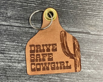Leather Cow Ear Tag Key Chain with "Drive Safe Cowgirl" and a Saguaro Cactus Engraved in it.