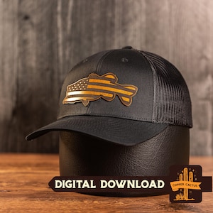 May include: A black baseball cap with a mesh back and a brown leather-like patch on the front. The patch is shaped like a fish and features a design of the American flag with stars and stripes. The text DIGITAL DOWNLOAD is visible at the bottom.