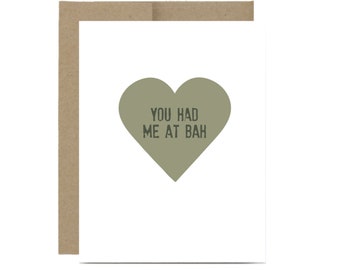 May include: A white card with a green heart that says "You had me at bah" on it. The card has a brown envelope.