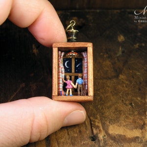 Miniature world, boy and girl holding hands while watching the starry sky. Made with tiny figurines inside small wooden box.