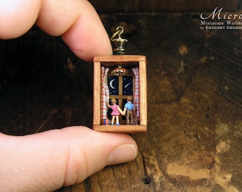 Miniature world, boy and girl holding hands while watching the starry sky. Made with tiny figurines inside small wooden box.