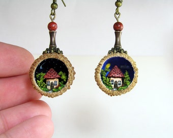 Miniature world earrings in acorn caps. Tiny little house in green forest under the night and day sky