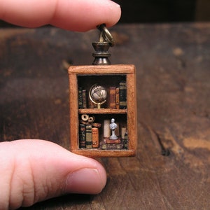 Miniature library pendant, full of tiny books, parchments, a globe and a bust