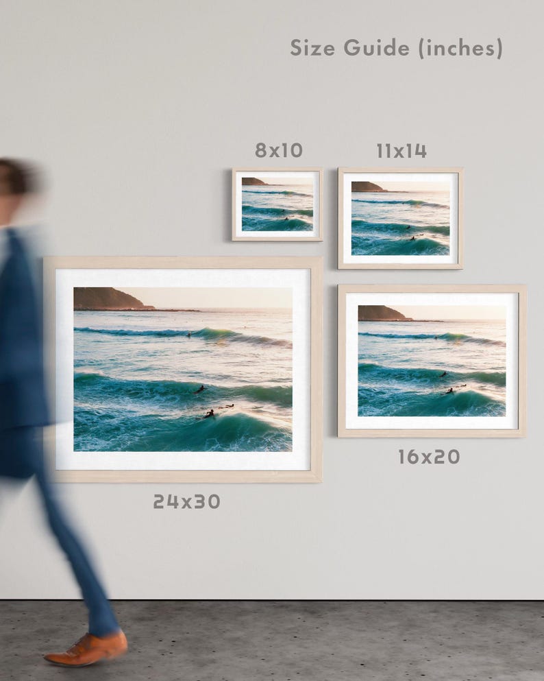 May include: Framed art prints of a coastal scene with surfers in the ocean. The prints are displayed in various sizes: 8x10, 11x14, 16x20, and 24x30 inches. The text "Size Guide (inches)" is visible.