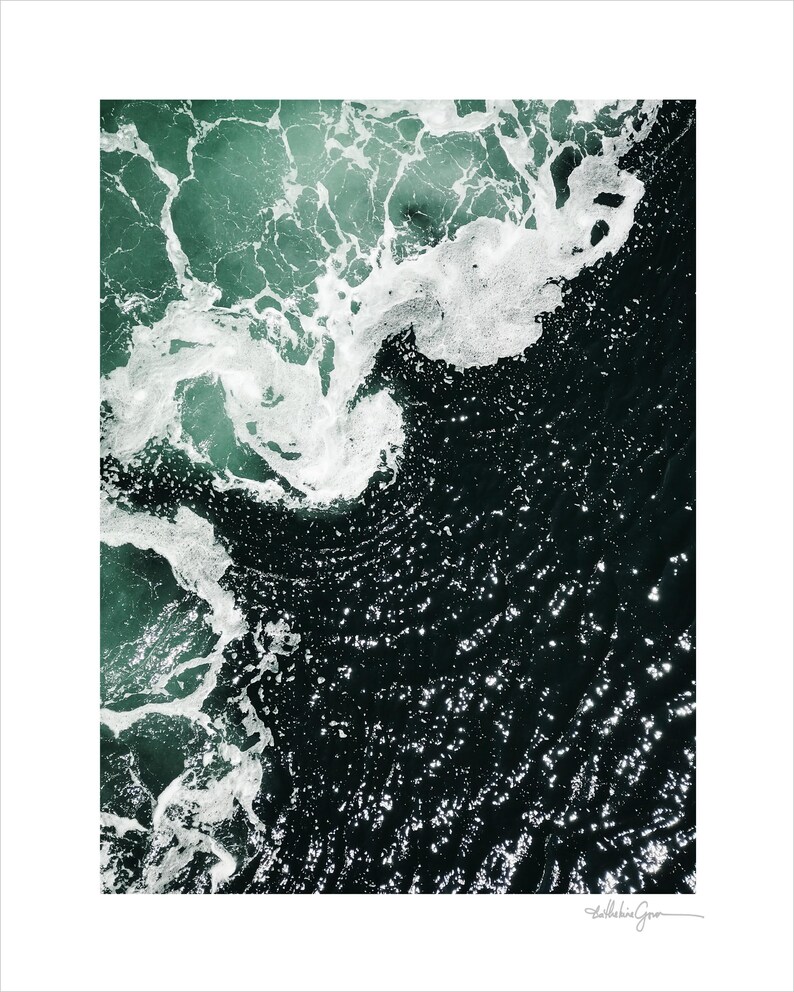 Op de afbeelding: Luchtfoto van oceaangolven. De afbeelding legt het contrast vast tussen het donkere, diepe water en de schuimige witte toppen van de golven. Het water gaat over van een diepblauwgroen naar een donkere, bijna zwarte kleur.