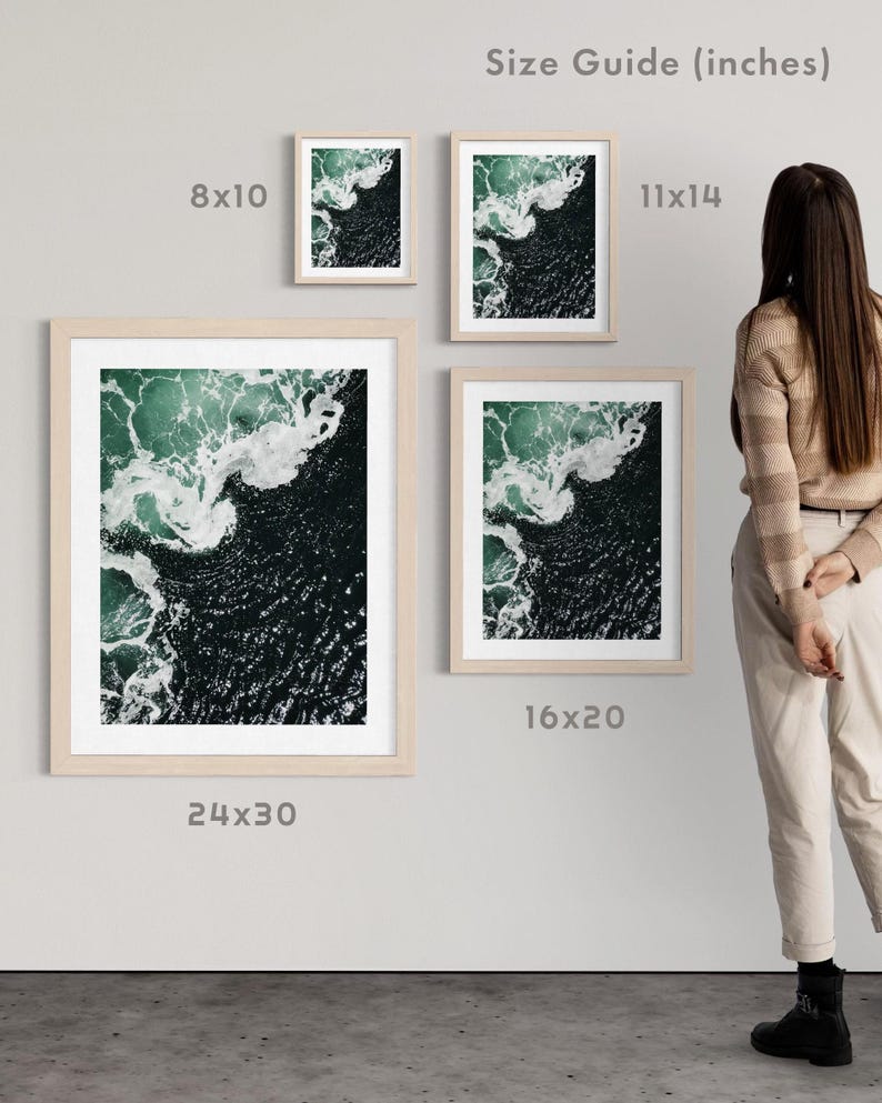 Op de afbeelding: Een collectie ingelijste kunstdrukken met een luchtfoto van oceaangolven. De prints worden in verschillende formaten getoond, waaronder 20x25 cm, 28x35 cm, 40x50 cm en 61x76 cm, met een licht houten frame. Het kunstwerk toont tinten groen en wit.