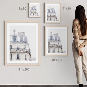 May include: Four framed prints of a building facade with a light-coloured exterior and a blue roof. The prints are displayed in various sizes: 20x25 cm, 28x35 cm, 40x50 cm, and 61x76 cm. The frames are light-coloured wood.