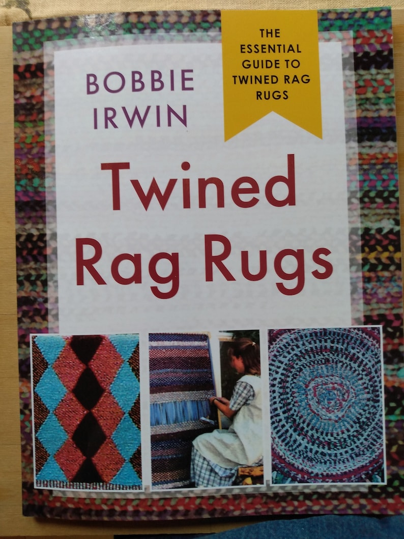 May include: Book cover titled "Twined Rag Rugs" by Bobbie Irwin. The cover features a yellow banner with the text "The Essential Guide to Twined Rag Rugs". The cover also features three images of rugs: a diamond pattern rug, a striped rug, and a round rug.