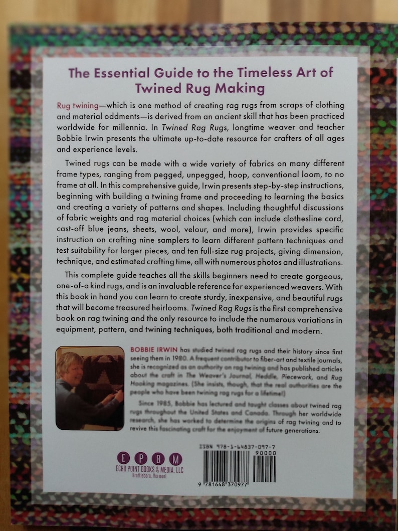 May include: The Essential Guide to the Timeless Art of Twined Rug Making book cover features a photo of Bobbie Irwin, a rug maker, and a close-up of the book's spine with the title and author's name. The book cover is a light blue with white text.