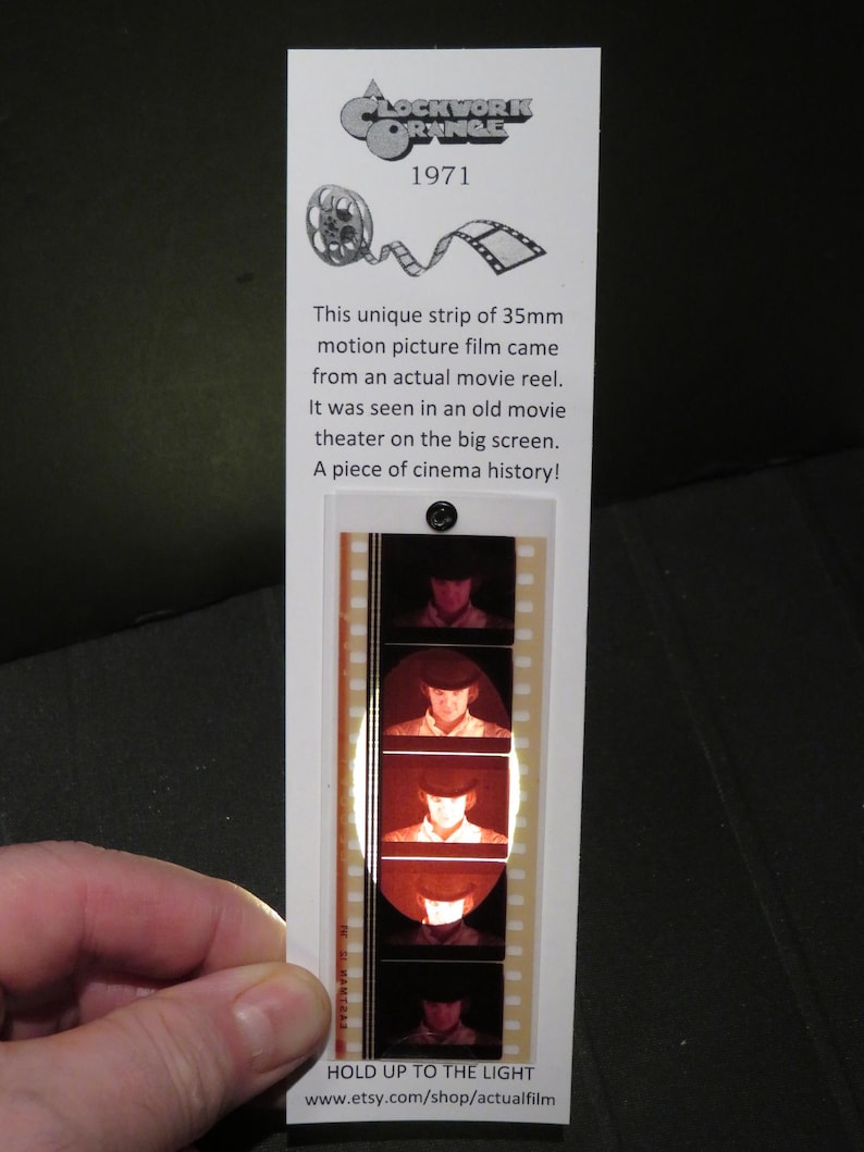 May include: A strip of 35mm motion picture film from the movie "A Clockwork Orange" (1971). The film strip features a close-up of the main character's face. Hold the film strip up to the light to see the image.