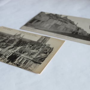 May include: Two vintage black and white postcards showing a building with a large, ornate roof. The top postcard depicts a street scene with a building in the background. The bottom postcard shows a close-up of the building's roof.