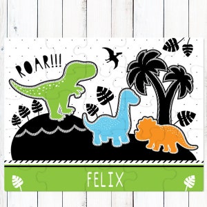 May include: A jigsaw puzzle featuring a green T-Rex with the text ROAR!!!, a blue long-necked dinosaur, and an orange triceratops. The scene includes black palm trees and leaves on a white dotted background, with the name FELIX on a green bar.