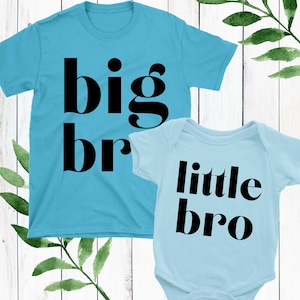 May include: Two blue t-shirts with black text. The larger shirt says "big bro" and the smaller shirt says "little bro".