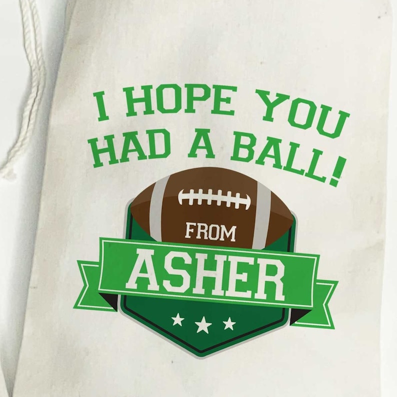 K&ouml;nnte beinhalten: Wei&szlig;e Stoff-Geschenk-Tasche mit gr&uuml;nem Text, der "Ich hoffe, du hattest viel Spa&szlig;!" lautet, mit einer gr&uuml;nen und braunen Fu&szlig;ballgrafik und dem Text "Von Asher" in einem gr&uuml;nen Banner.