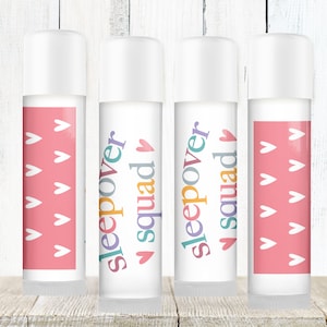 May include: Four white lip balm tubes with colorful labels. The labels have a pink background with white hearts and the text "sleepover squad" in different colors.