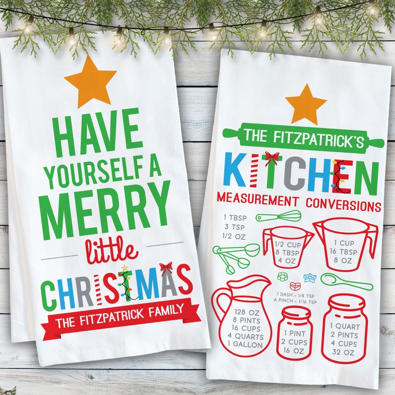 May include: Two white kitchen towels with a Christmas theme. One towel says "Have yourself a merry little Christmas" with the Fitzpatrick family name. The other towel has a kitchen measurement conversion chart with the Fitzpatrick's Kitchen name.