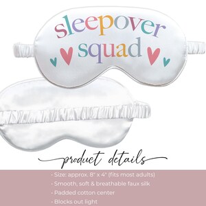 Puede incluir: M&aacute;scara para dormir blanca con las palabras "sleepover squad" en letras coloridas y dos corazones rosas. La m&aacute;scara mide aproximadamente 20 cm x 10 cm y est&aacute; hecha de seda artificial suave, suave y transpirable. Tiene un centro de algod&oacute;n acolchado y bloquea la luz.