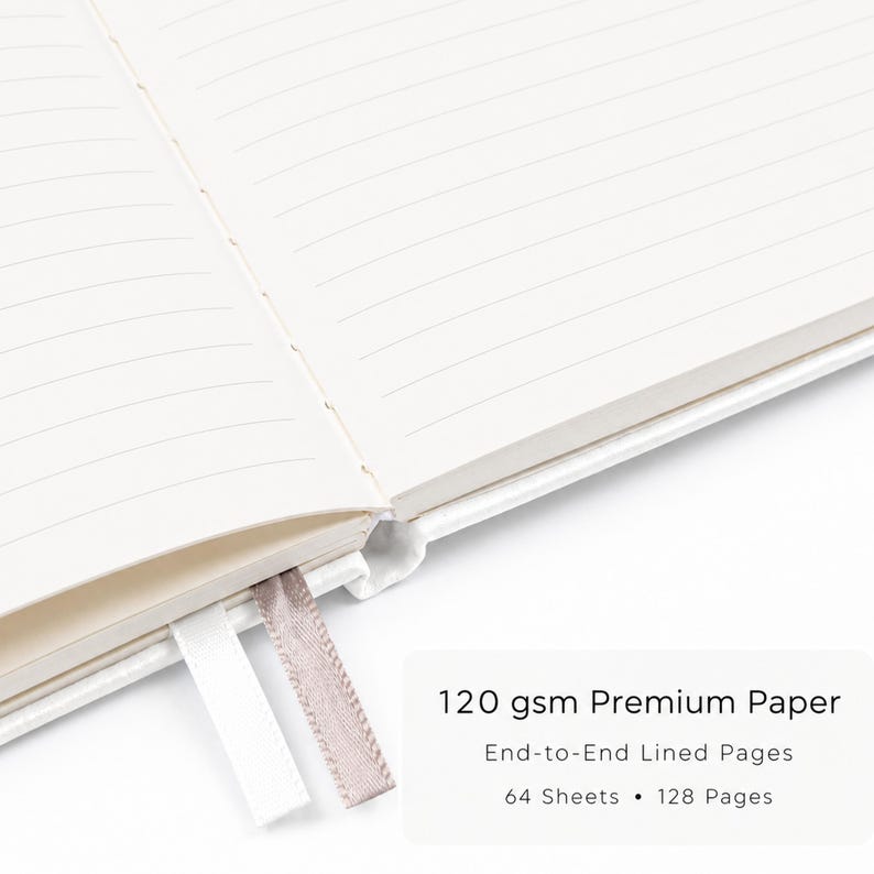 May include: An open notebook with cream-colored lined pages, featuring a white ribbon bookmark and a light brown ribbon bookmark. Text on the image reads: 120 gsm Premium Paper, End-to-End Lined Pages, 64 Sheets, 128 Pages.