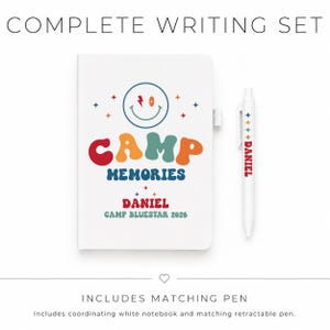 May include: A white notebook and matching retractable pen set. The notebook cover features a smiley face, stars, and the text "CAMP MEMORIES DANIEL CAMP BLUESTAR 2026". The pen is white with the name "DANIEL" and small star icons printed on it.