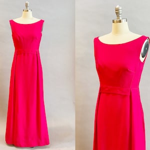 May include: A sleeveless, floor-length dress in a vibrant pink color. The dress has a simple, elegant design with a scoop neckline and a fitted bodice. The skirt is slightly flared and falls to the floor.