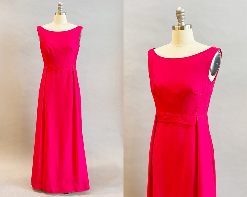 May include: A sleeveless, floor-length dress in a vibrant pink color. The dress has a simple, elegant design with a scoop neckline and a fitted bodice. The skirt is slightly flared and falls to the floor.