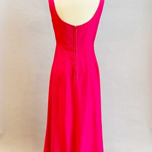 May include: A long, sleeveless, fuchsia pink dress with a back zipper closure.