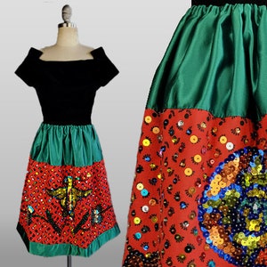 May include: A black and green skirt with a red and green sequined bottom. The skirt has a wide waistband and a full skirt.