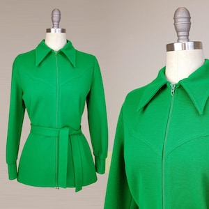 May include: A bright green jacket with a zipper closure and a wide belt. The jacket has a collar and long sleeves.