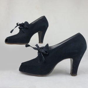K&ouml;nnte beinhalten: Ein Paar schwarze Wildlederschuhe mit Absatz, Peeptoe und Schn&uuml;rung.