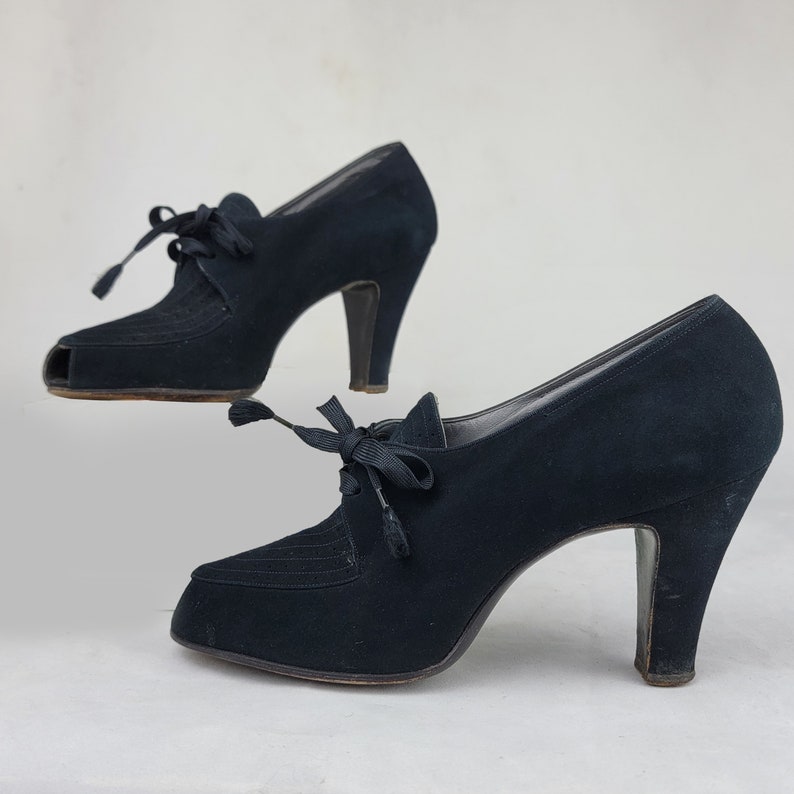 K&ouml;nnte beinhalten: Ein Paar schwarze Wildlederschuhe mit Absatz, Peeptoe und Schn&uuml;rung.