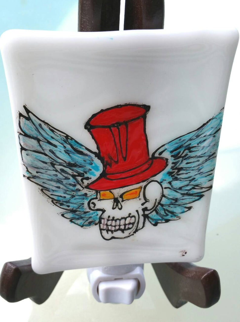 a gothic air nightlight in fusion glass Made entirely by hand Skull with red hat with wings