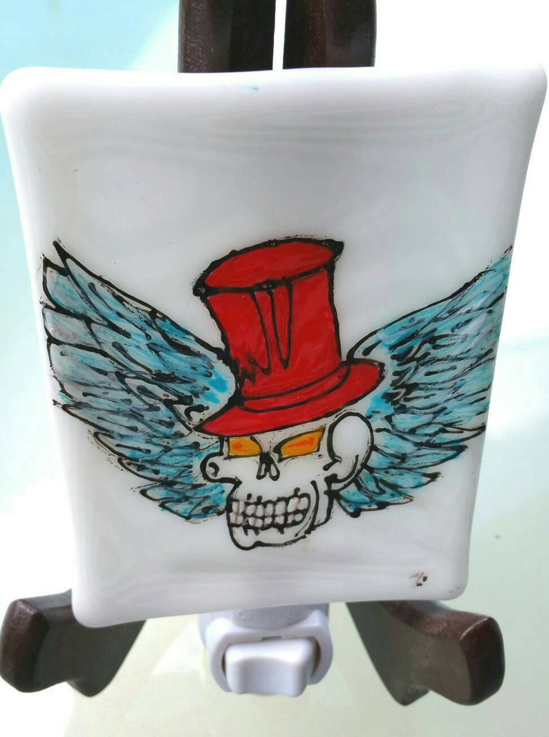 a gothic air nightlight in fusion glass Made entirely by hand Skull with red hat with wings