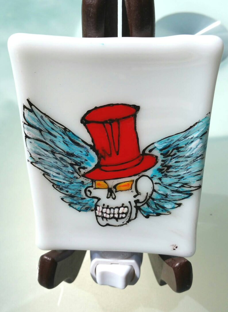 a gothic air nightlight in fusion glass Made entirely by hand Skull with red hat with wings