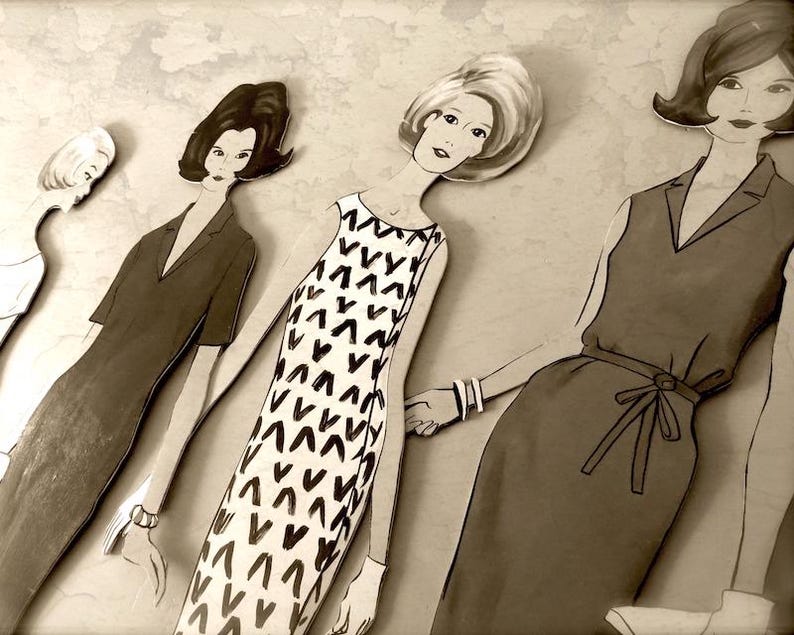 May include: Four paper dolls with black hair and black and white dresses. The dolls are wearing different styles of dresses, including a dress with a V-neck and a dress with a scoop neck.