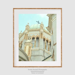 Puede incluir: Una vista cercana de un gran edificio ornamentado con una c&uacute;pula verde y una cruz en la parte superior. El edificio est&aacute; hecho de piedra de color claro y tiene muchas ventanas y arcos. El edificio est&aacute; parcialmente oscurecido por una pared en el lado izquierdo de la imagen.