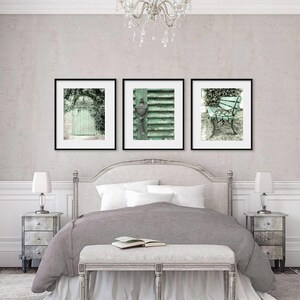 May include: Three framed prints of vintage green doors and a bench in a garden setting. The prints are hung above a white bed with gray bedding and a white bench at the foot of the bed.