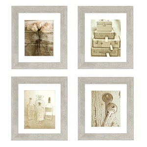 May include: Set of four framed sepia-toned prints with vintage themes. The first print shows a bouquet of flowers tied with a ribbon. The second print shows a stack of vintage suitcases with tags. The third print shows three glass bottles. The fourth print shows two keys with the word "LOVE" on them.