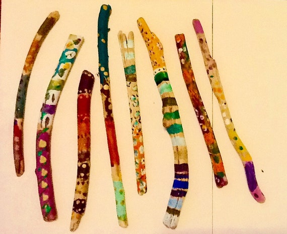 Hand-painted driftwood wands made from found ocean objects — each one is a tiny sculptural spell that washed ashore.
