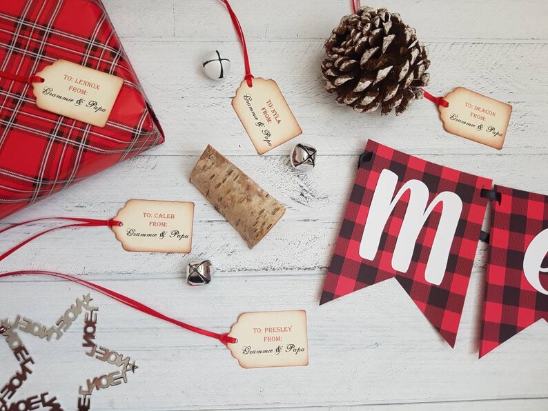 Puede incluir: Papel de regalo a cuadros rojos y negros con una etiqueta de regalo que dice "TO: LENNOX FROM: Gramme & Papa". Hay varias otras etiquetas de regalo con un texto similar, una pi&ntilde;a y una pancarta que dice "Merry".
