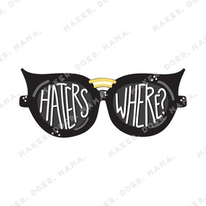 Puede incluir: Gafas de sol negras con el texto "HATERS WHERE?" en blanco y en negrita. Las gafas tienen un acento amarillo en el puente y pequeños puntos blancos en la montura. La imagen está sobre un fondo blanco.