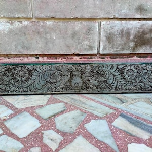 May include: A carved wooden panel with intricate floral and bird designs. The panel is painted in a dark green color and has a distressed finish.