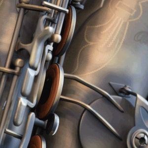 May include: Close-up of a silver saxophone with brown leather pads. The saxophone has a decorative design on the body.