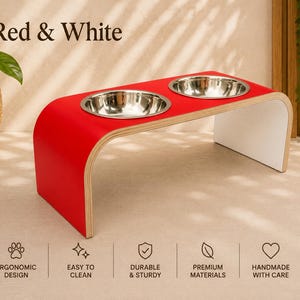 Red and white raised dog bowl stand with stainless steel bowls, handmade elevated wooden pet feeder in a modern home, stylish feeding station for dogs and cats.