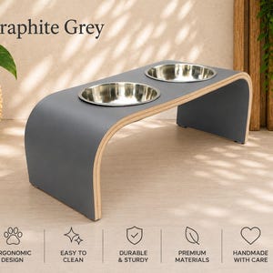 Graphite grey raised wooden dog bowl stand with stainless steel bowls, modern elevated pet feeder in a bright contemporary home, handmade dog and cat feeding station.