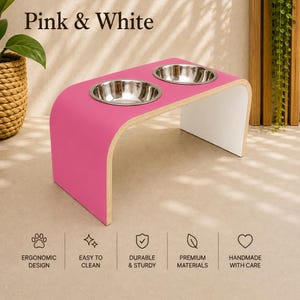 Pink and white raised dog bowl stand with stainless steel bowls, handmade elevated wooden pet feeder in a bright contemporary home, modern feeding station for dogs and cats.