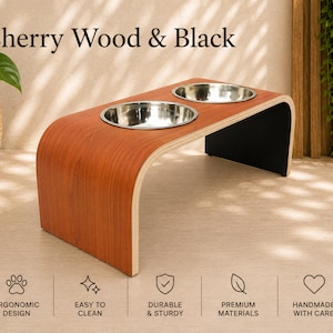 Cherry wood and black raised dog bowl stand with stainless steel bowls, handmade elevated pet feeder in a modern home, ergonomic feeding station for dogs and cats.