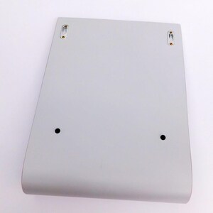 May include: A white, rectangular wall shelf with rounded edges and two small black dots on the front. The shelf has two small, silver-colored hooks on the top, one on each side.